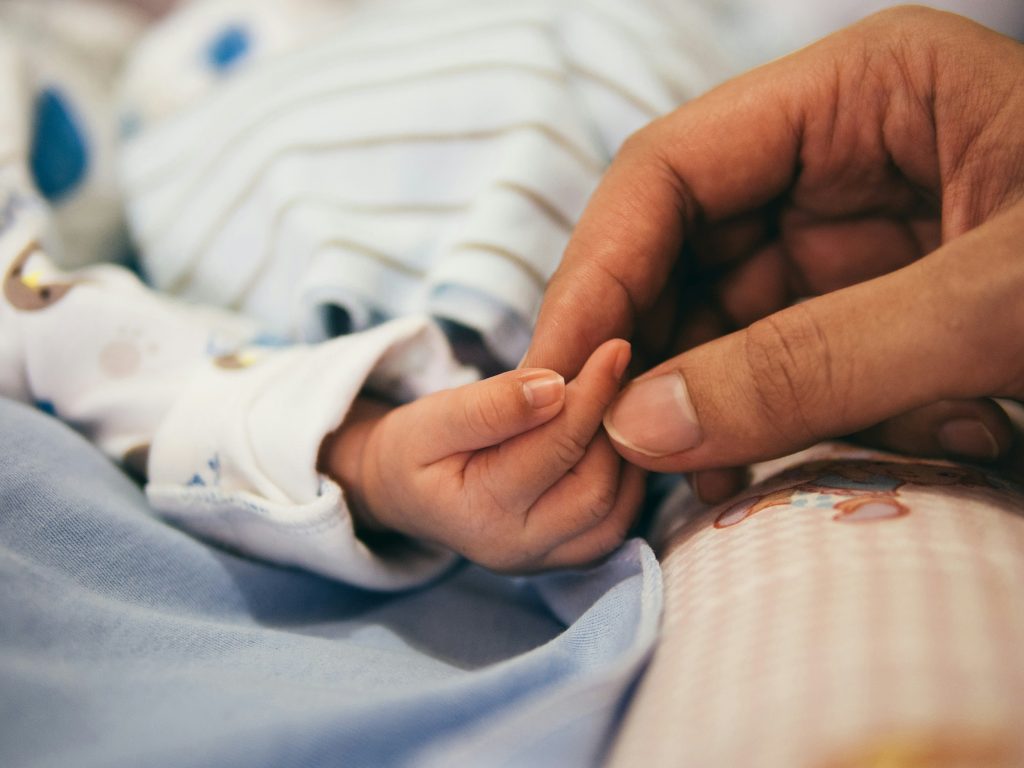 Baby;s hand holding an adult